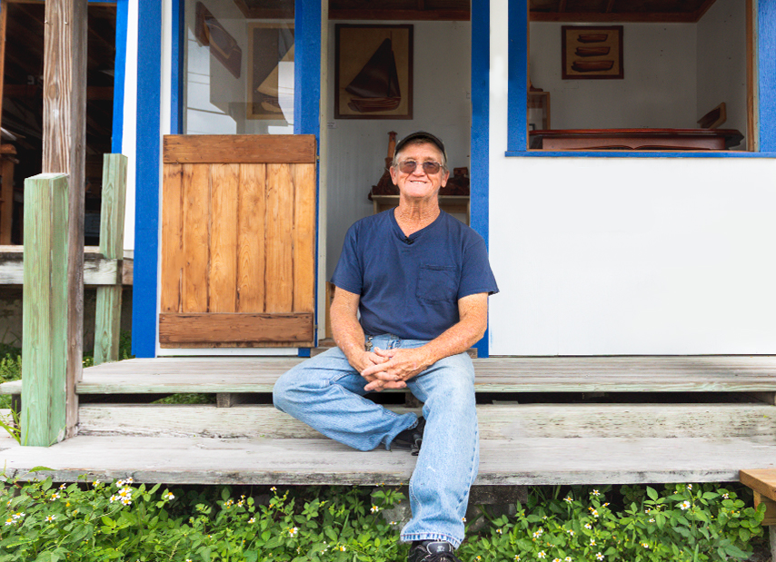 Andy Albury sitting in front of his home