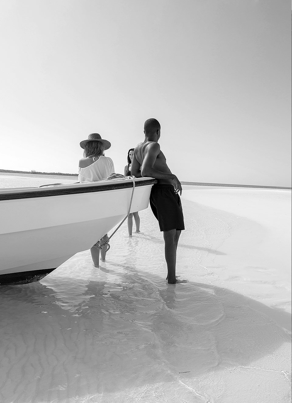 Black and white photo with couple leaning on a boat