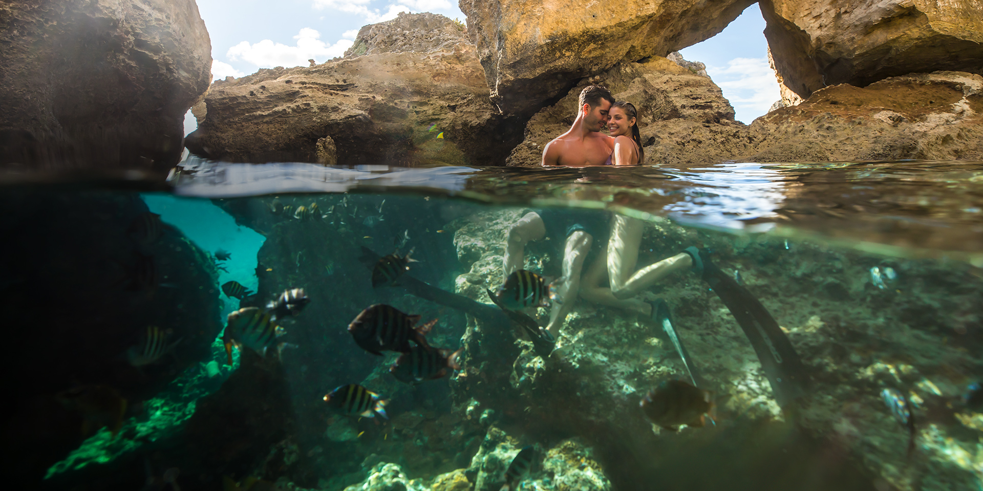 couple on the reef with fish around